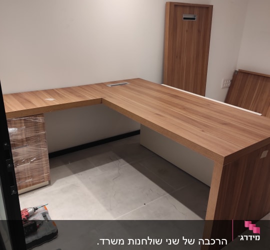 שולחן עץ גדול עם מקדחה וארגזי כלים על הרצפה